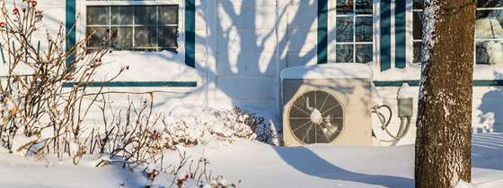 an outdoor heat pump unit in the snow
