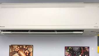 A heat pump at Rutland Community Cupboard on a wall above images of fruit, vegetables, and bread.