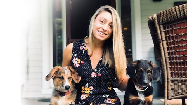 picture of a girl with long blonde hair posing next to her two dogs
