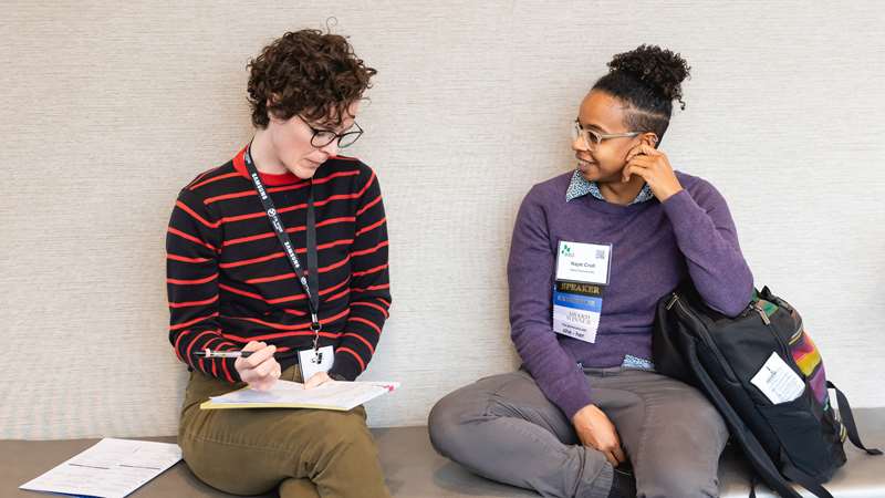 Two conference attendees speaking between sessions
