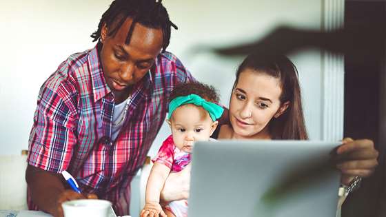 A family looks at a computer together