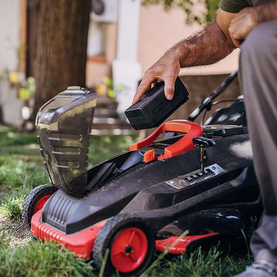 an electric lawn mower with battery being inserted