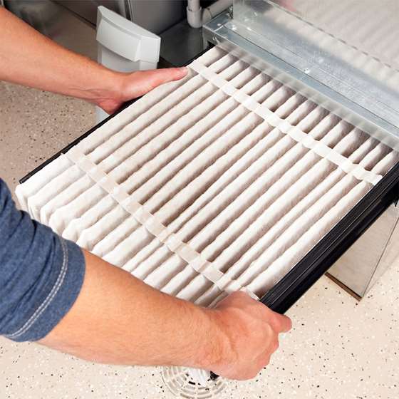A man replaces a furnace filter