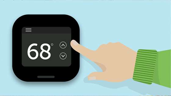 A hand adjusts a thermostat
