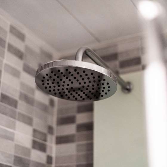 Image of a shower head as a symbol of areas in a home that use hot water