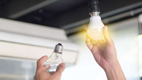 Hand switching out a light bulb