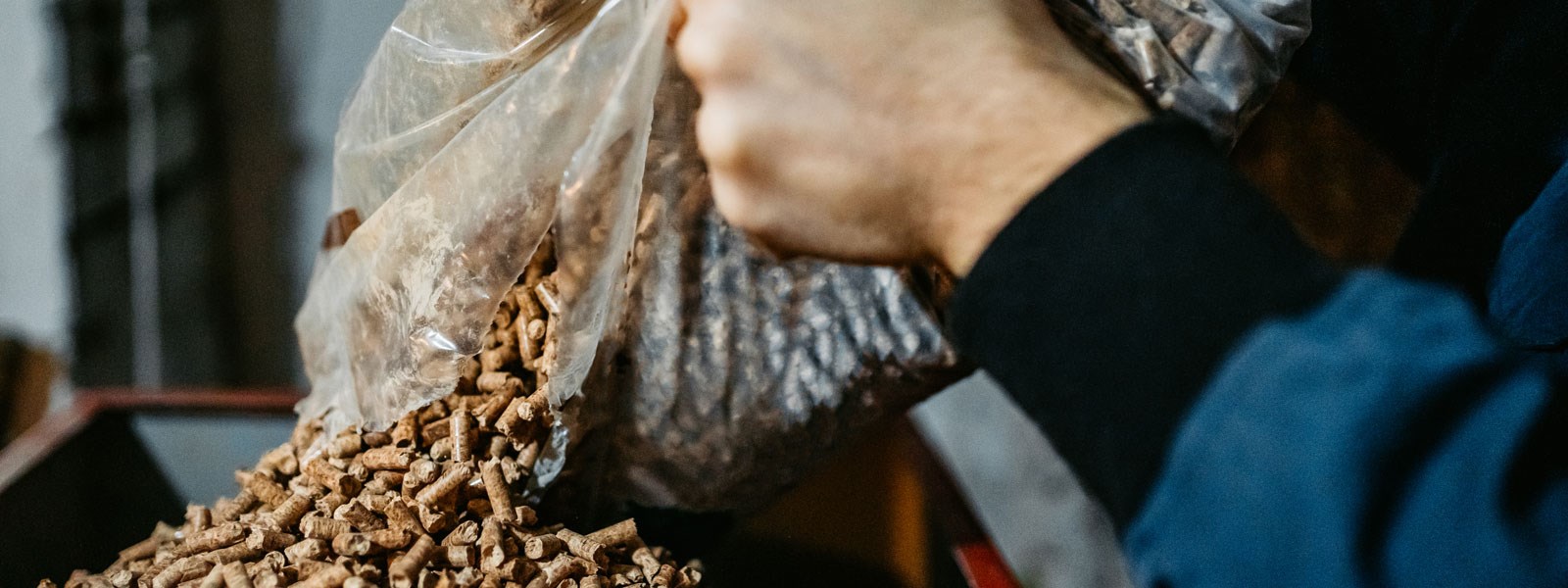 A bag of pellets is poured into a pellet stove