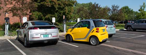 Two electric vehicles charging in a parking lot