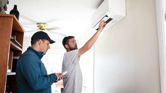 contractors checking the installation of a heat pump inside