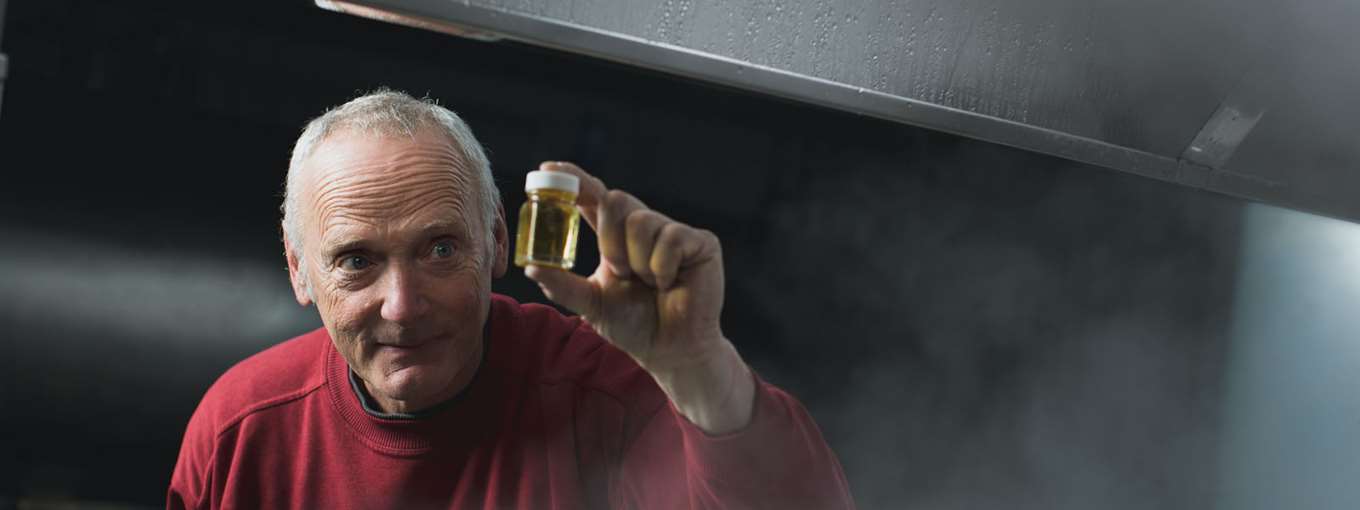 Glenn Goodrich holds up a small vial of sap