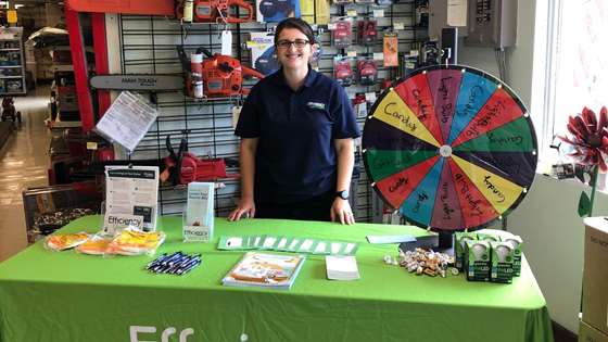 Efficiency Vermont Community Manager Michelle McCutcheon-Schour stands behind an Efficiency Vermont table at a hardware store.