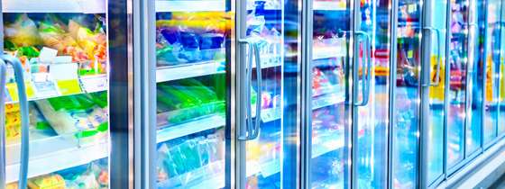 Close-up of glass-door refrigerators containing frozen foods in a grocery store