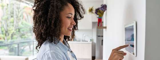 A woman looks at her smart home system