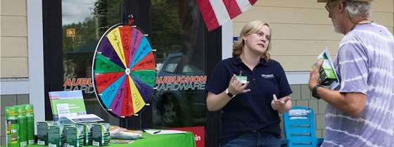 Becca White talks to a Vermonter in front of an Efficiency Vermont table