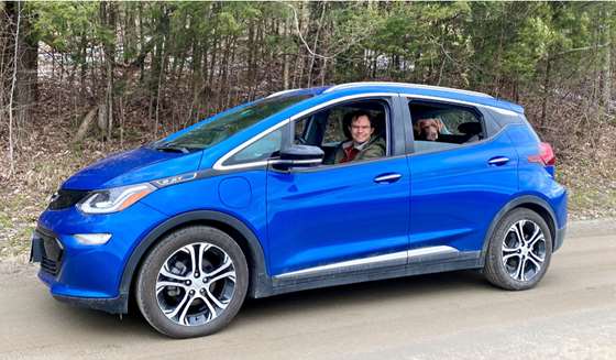 Dave Roberts on a dirt road with his dog, Rosalita, in his Chevy Bolt