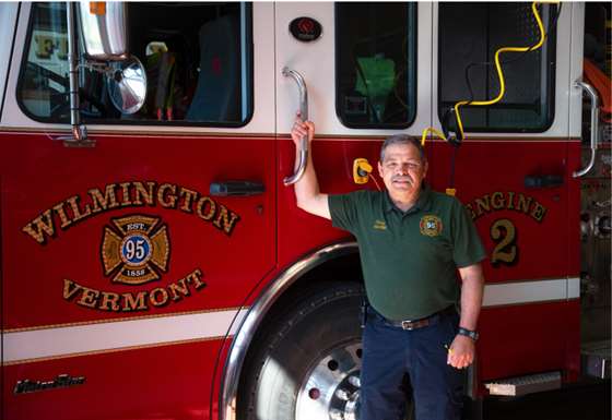 fire chief Scott morre stands in front of a fire truck 