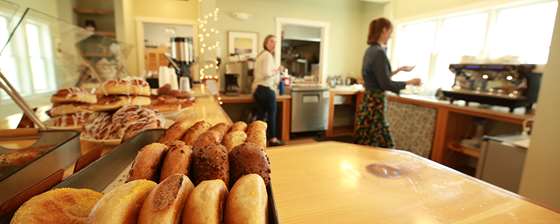 a scene behind the counter of the cafe showing two cafe workers