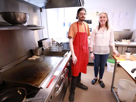 cafe employees in apron stand in the kitchen 