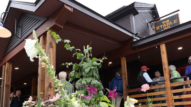 A photo of the Stable Inn with people enjoying the front porches