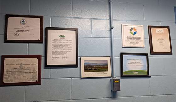 framed awards on a painted cinder block wall