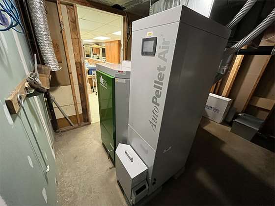 pellet furnace shown in a basement equipment room