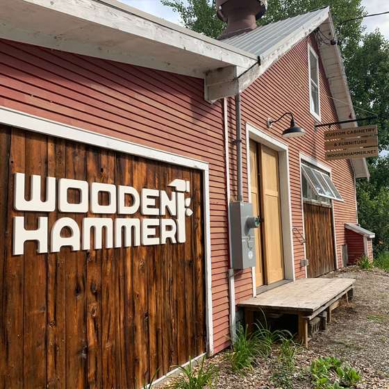 stick built building painted red with a large sign that says Wooden Hammer