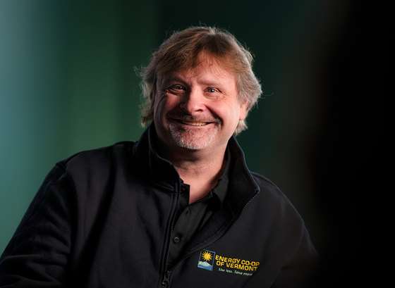 photo of a smiling middle age white man in a black work shirt