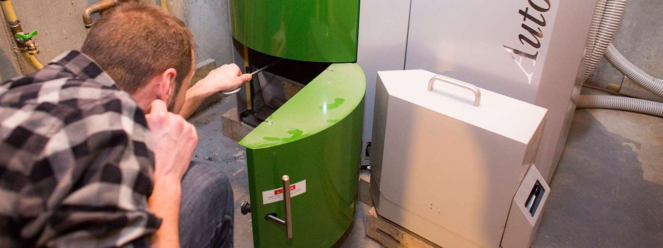 Kyle Emerson opens the door to his pellet boiler