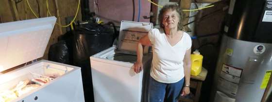 Gloria Powers stands next to her new efficient appliances