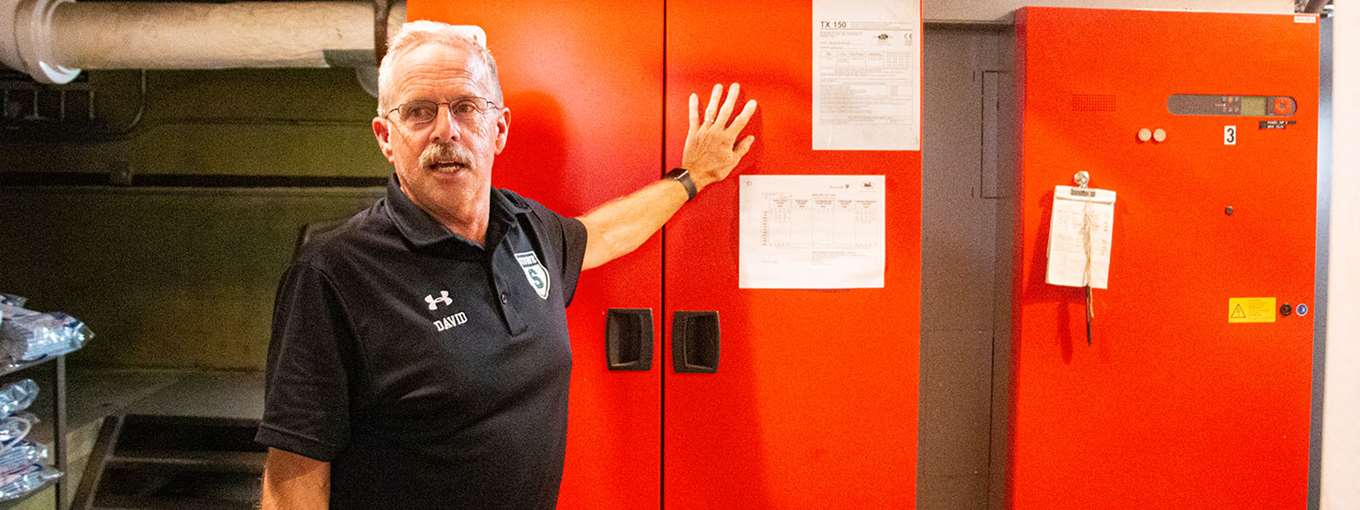 Dave Bullis stands in front of equipment in Stowe High School