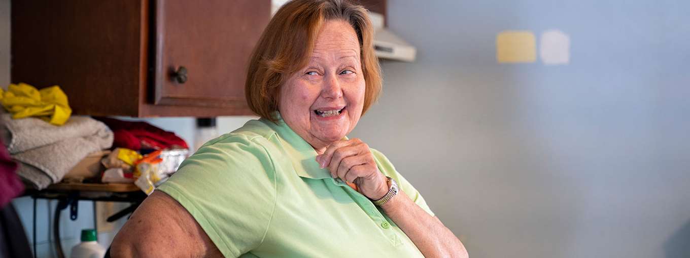 Julie sits in front of her heat pump