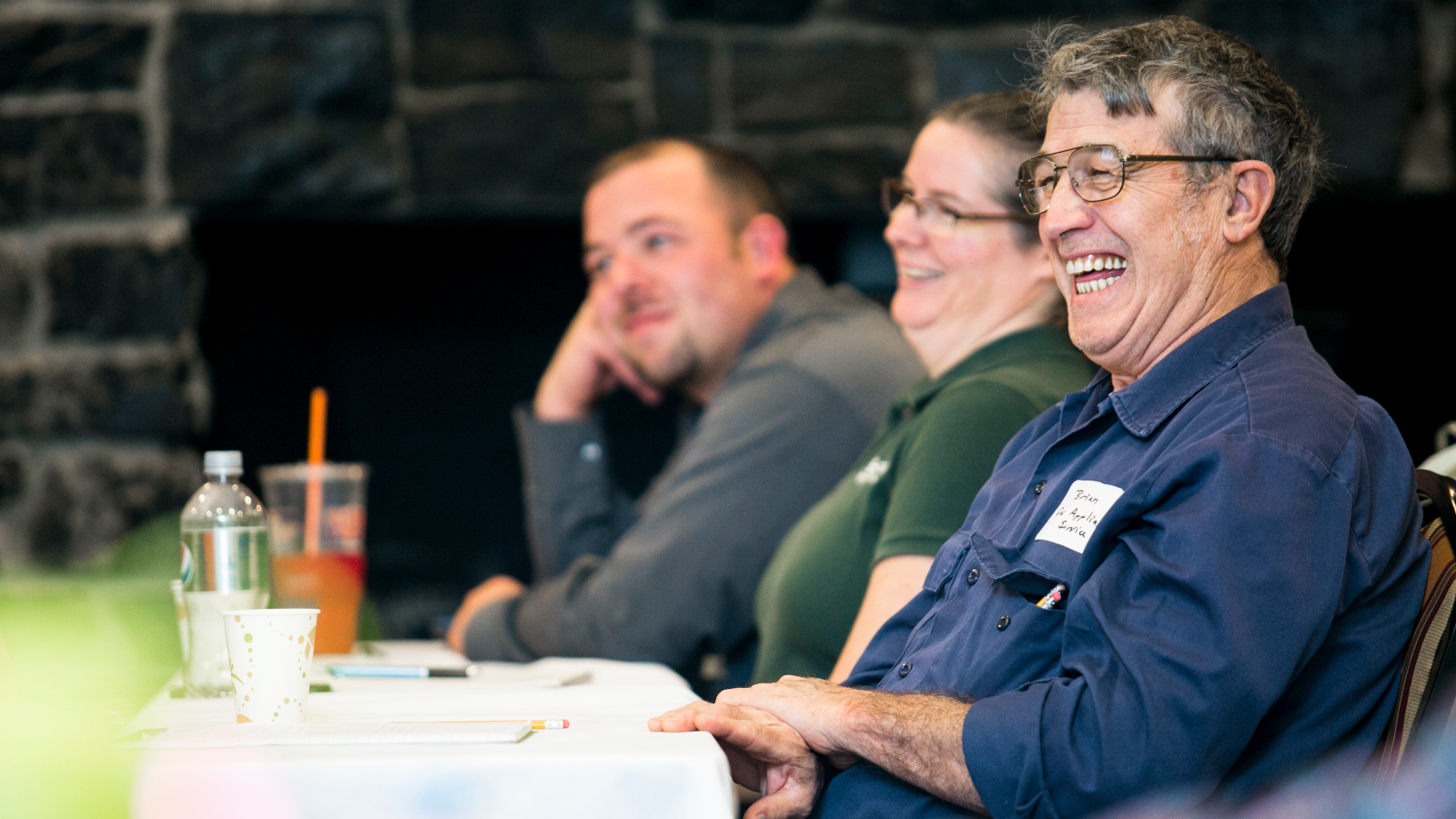 two men and a women laughing at a table